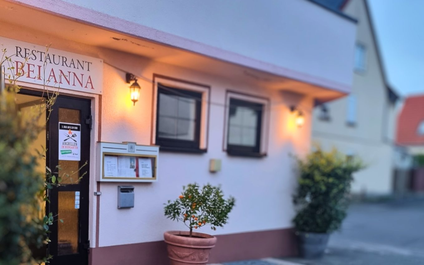 Eingang von Bei Anna in der Christinenstraße 17 am Abend mit beleuchteten Laternen