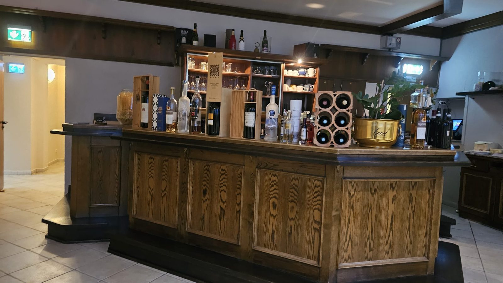 Die Theke aus dunklem Holz mit Wein- und Spirituosenflaschen